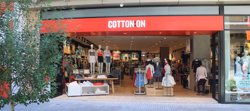 The finished Cotton On storefront at City Creek Center — a wide glass shopfront under a red sign band, open to the outdoor mall walkway